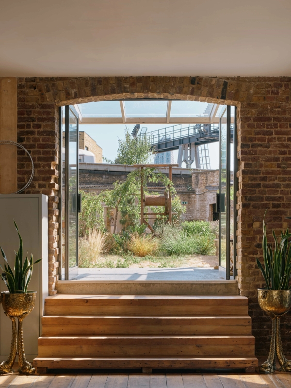 Interior view from The Lounge SE1 looking out through glass doors to the sunny courtyard garden.
