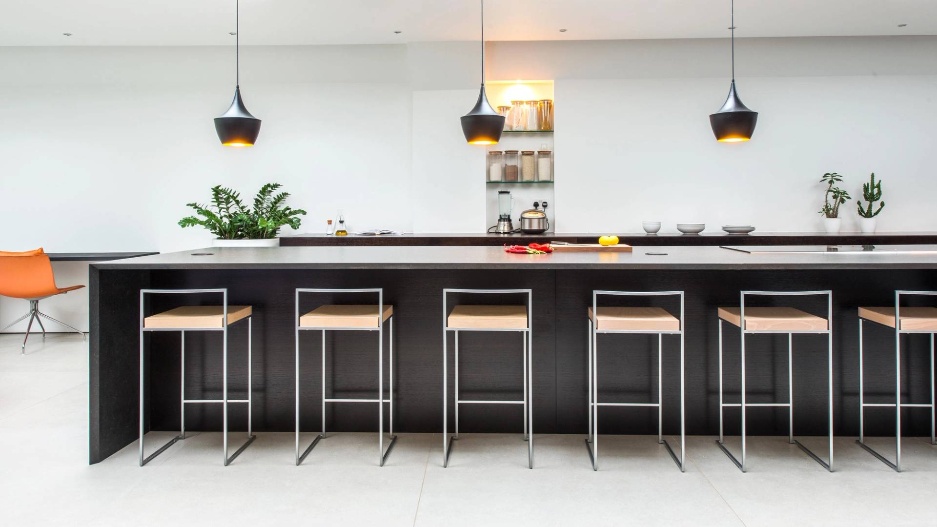 Dark kitchen island breakfast bar with modern high stools set under pendant lighting, Love Locations SW6.