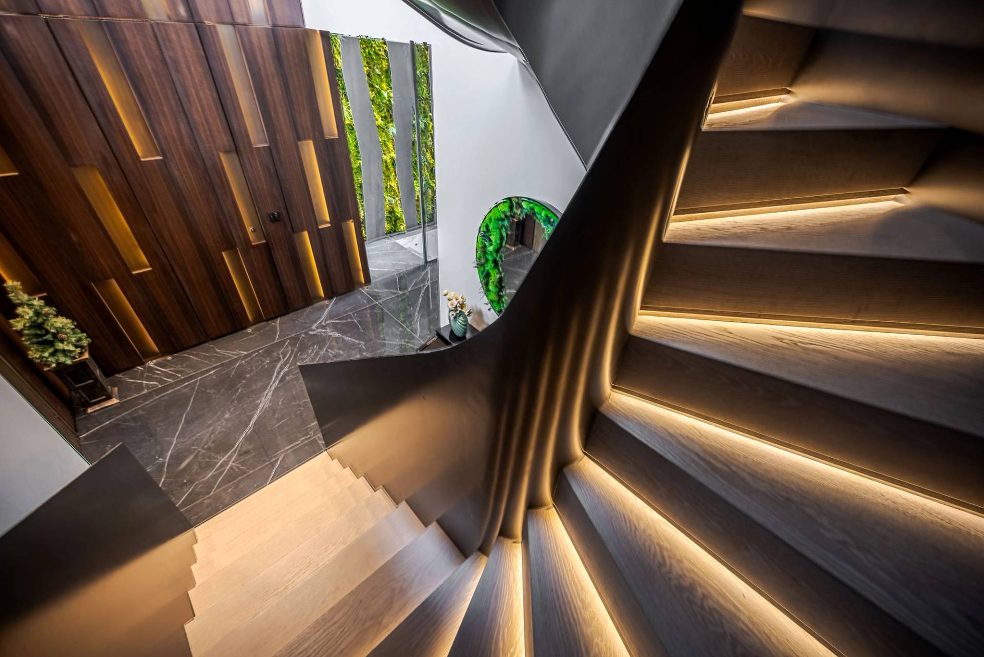 Helical timber and dark metal staircase detail with LED step strip lighting, Love Locations SW11.