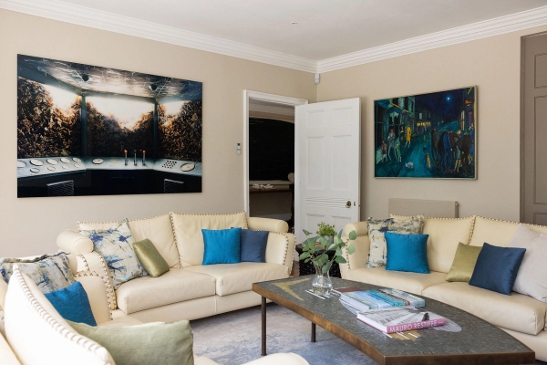 Love Locations contemporary country house interior West Sussex: Eclectic sitting space contrasting traditional cornicing with bold modern abstract paintings and cream leather seating.