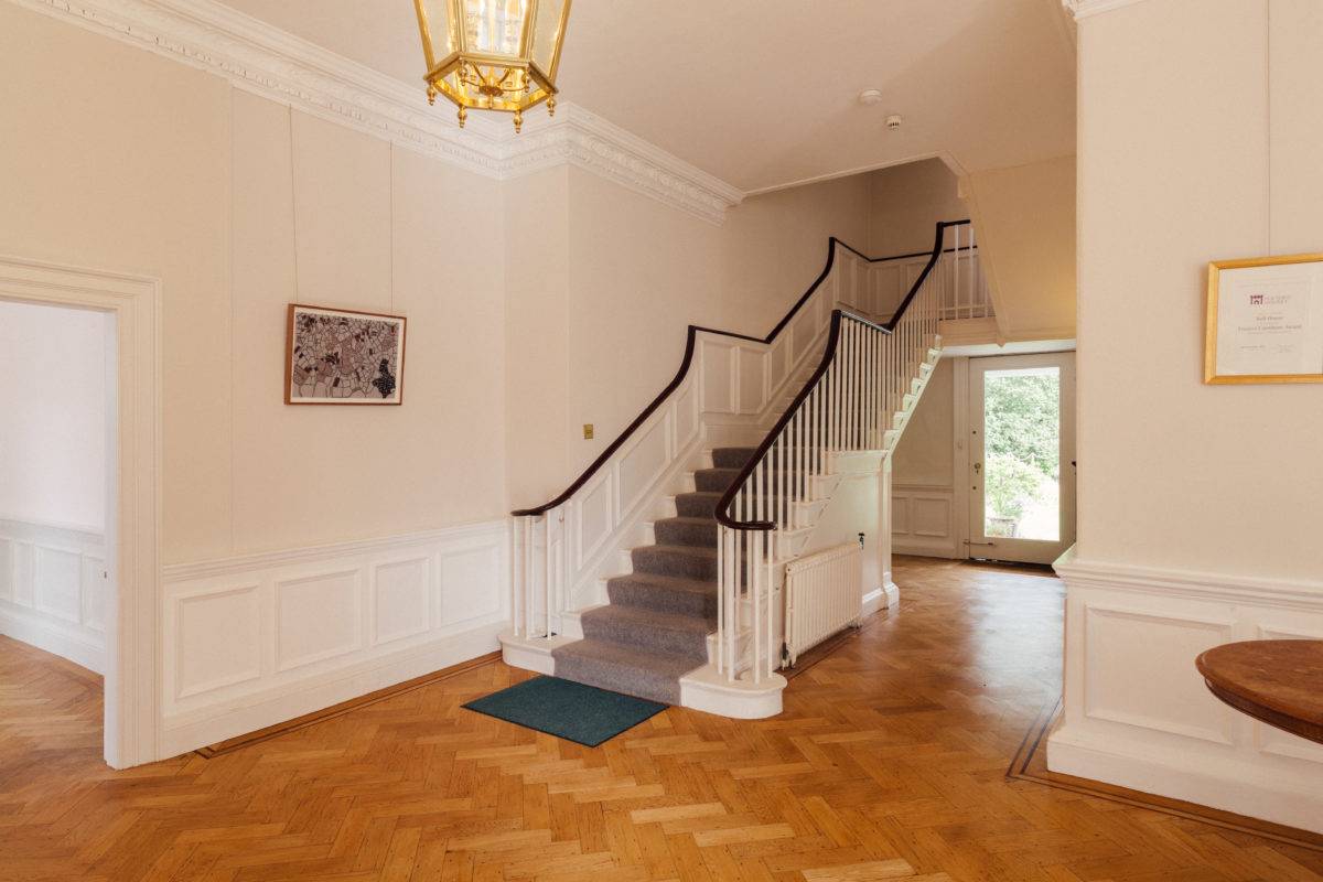 Grand entrance hall featuring a sweeping staircase, dark handrail, and traditional lantern lighting, ideal for feature film productions, Love Locations.