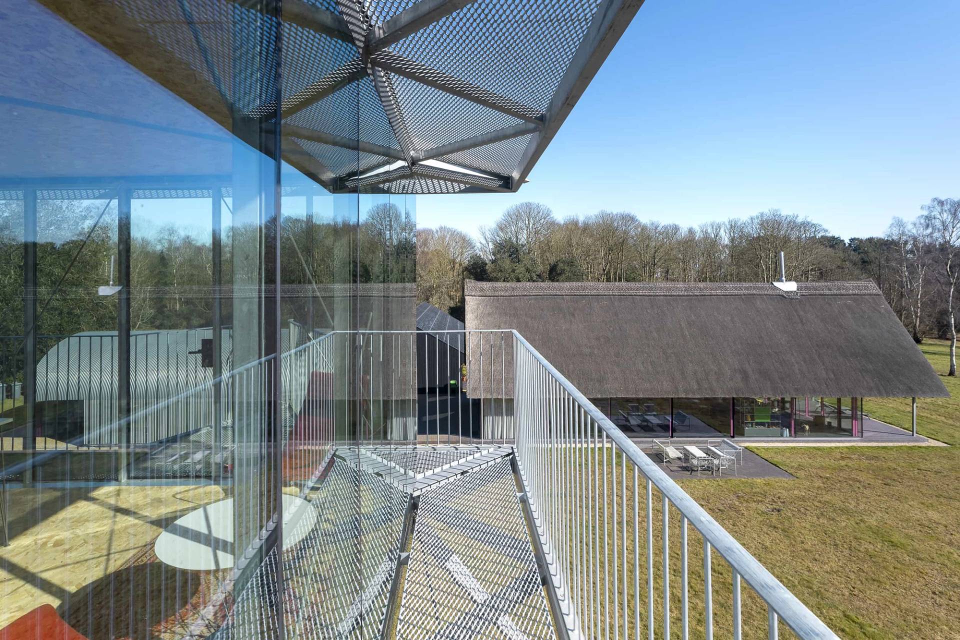 High-angle steel walkway bridge connecting elevated glass structures in a modern architectural estate, Love Locations IP17.