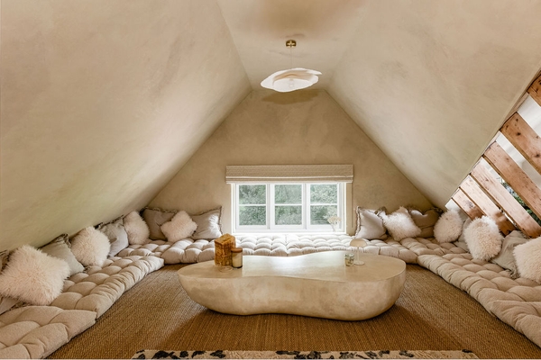 Stylish loft living space with feature window and curved furniture at Love Locations property in Liss, Hampshire GU33.