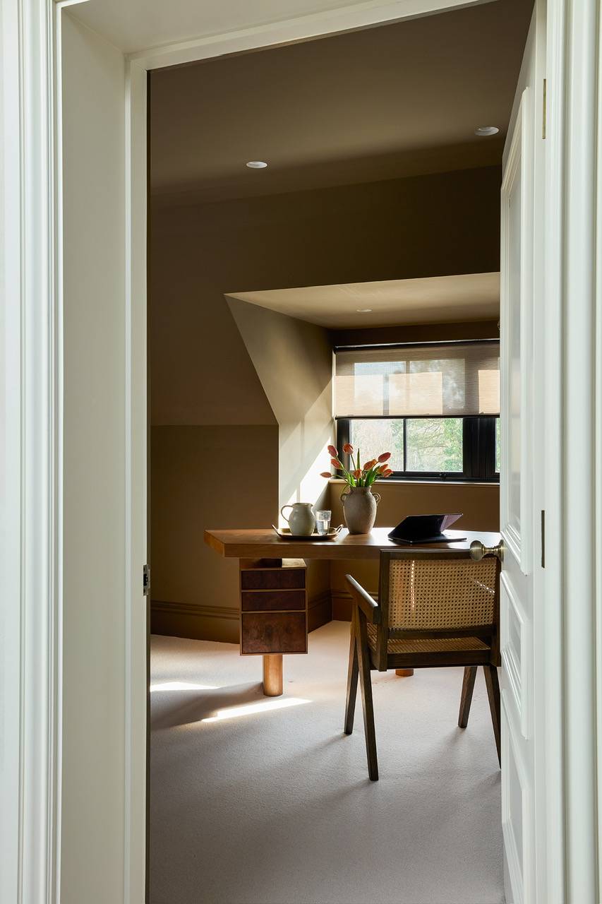 Charming attic home office location in Hertfordshire featuring a rustic wooden desk, cane chair, and sloped eaves, perfect for remote work lifestyle campaigns, Love Locations.