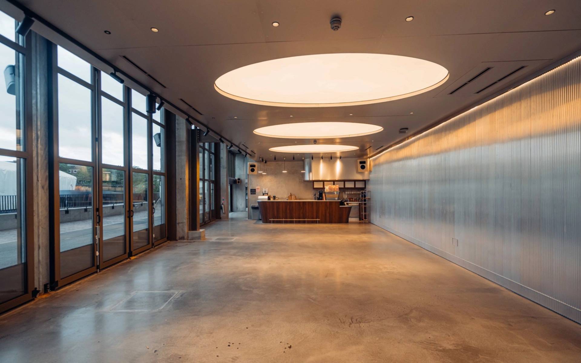 Wide interior view of a modern acoustic bar film location in Brentford TW8 by Love Locations, featuring polished concrete flooring and industrial ceilings.