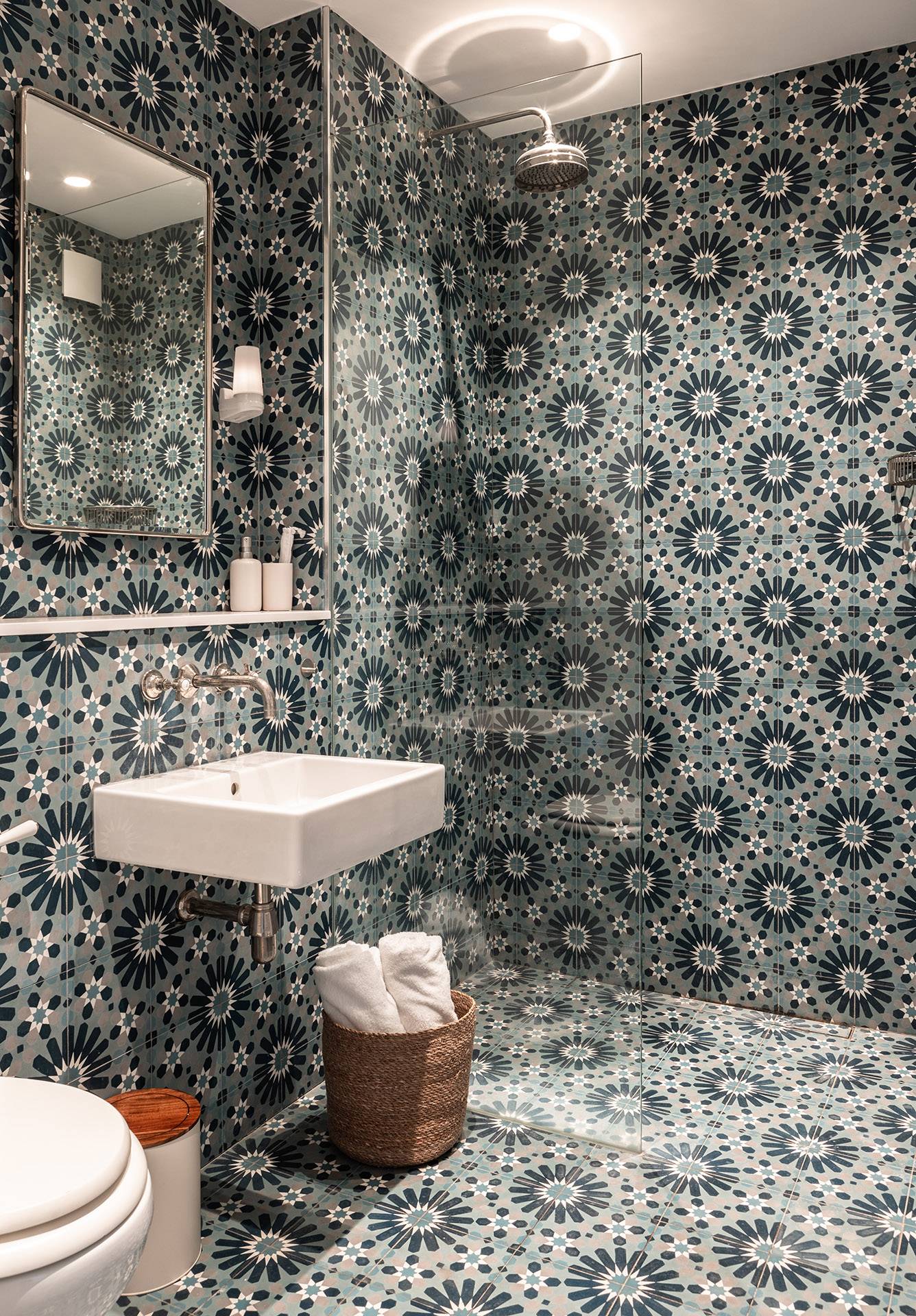 Bold blue geometric tiled bathroom location featuring a modern white floating sink, ideal for creative commercial backdrops via Love Locations.
