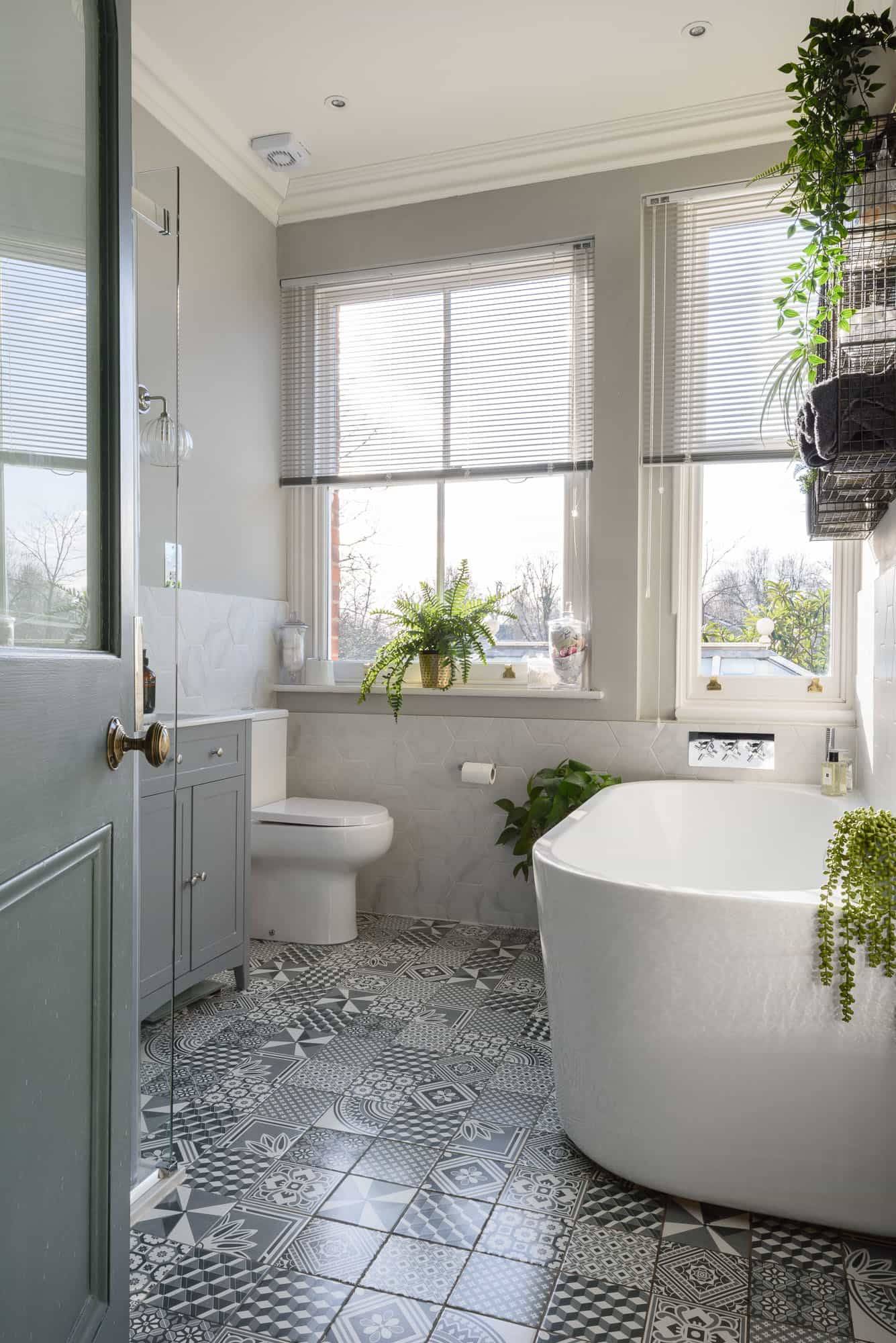 Bathroom location featuring a freestanding soaking tub, patterned floor tiles, and sash window light, Love Locations TW11.