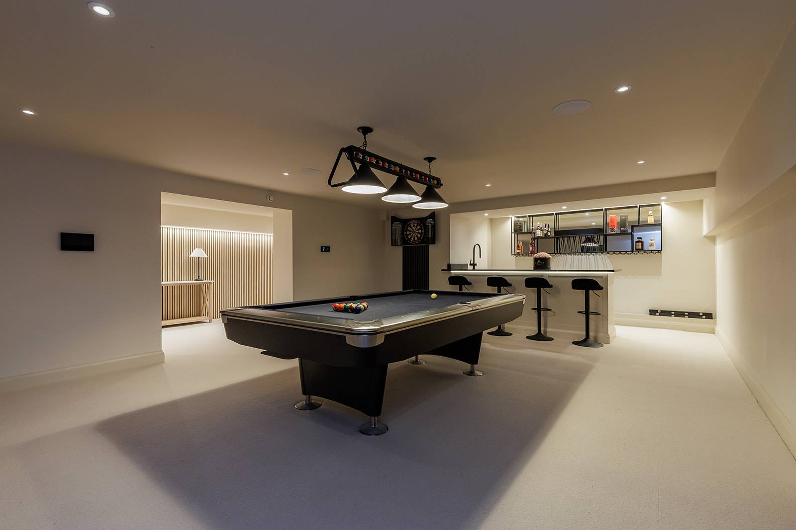 Subterranean games lounge featuring a pool table, modern bar area, and recessed ceiling lighting, Love Locations RH13.