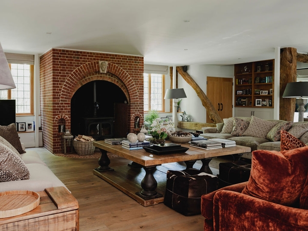Character living room featuring a traditional brick ingot fireplace and exposed wooden support pillars, ideal for rural period drama scenes, Love Locations.