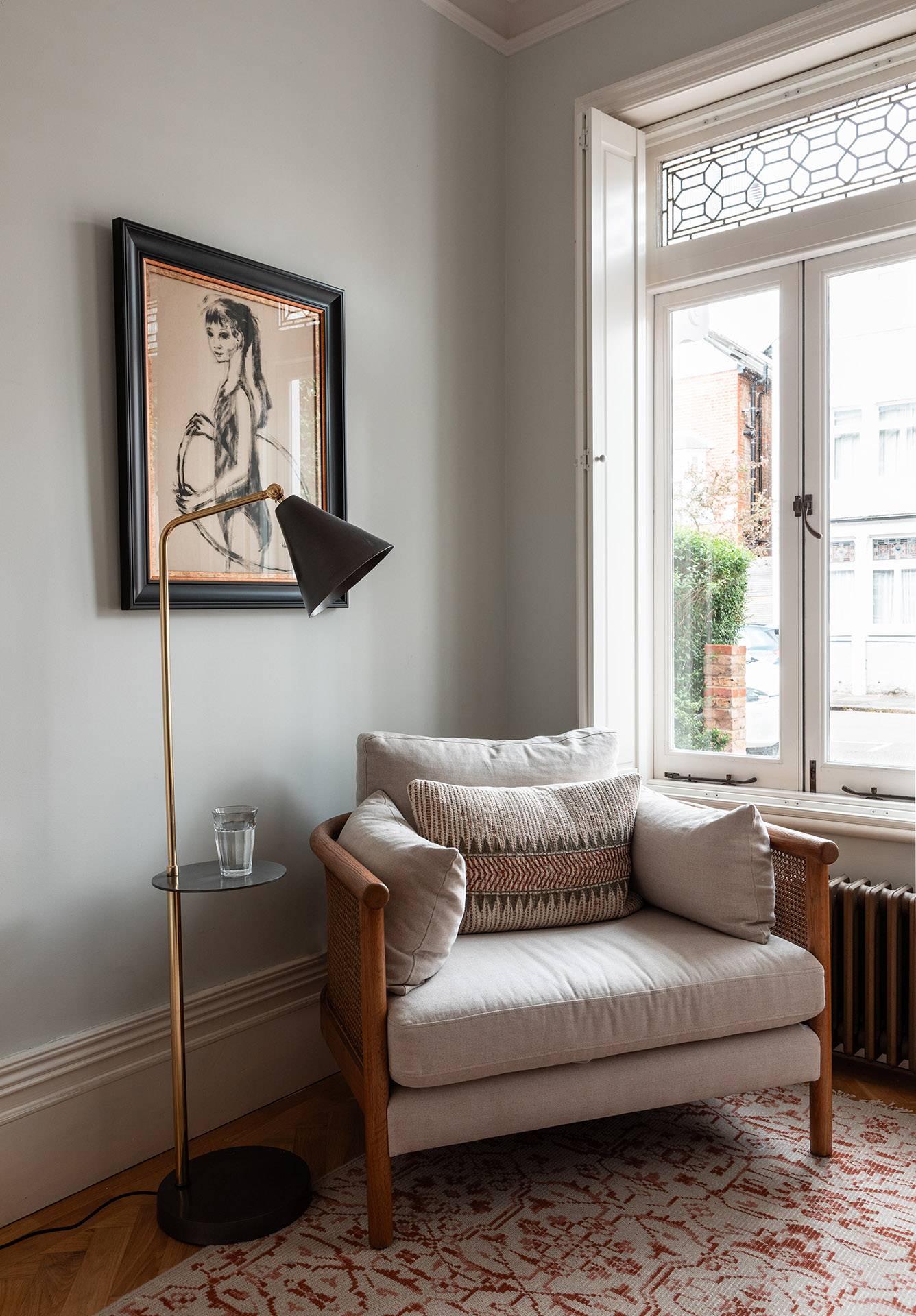 Comfortable armchair corner next to a large sash window and floor lamp, perfect for cozy lounge apparel campaigns, Love Locations.