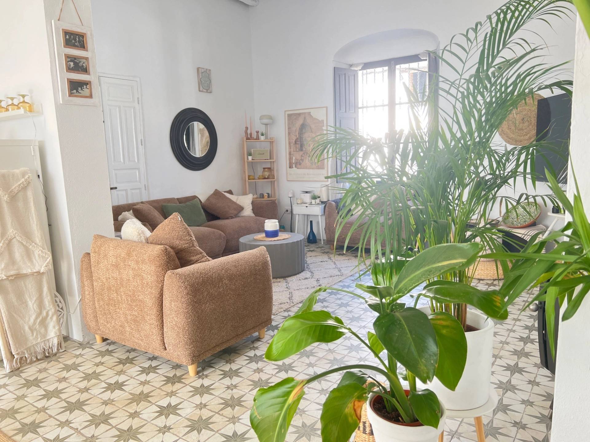 Light-filled Andalucian living room film location in Jimena de la Frontera through Love Locations, displaying comfortable seating, potted indoor houseplants, and warm natural lighting.
