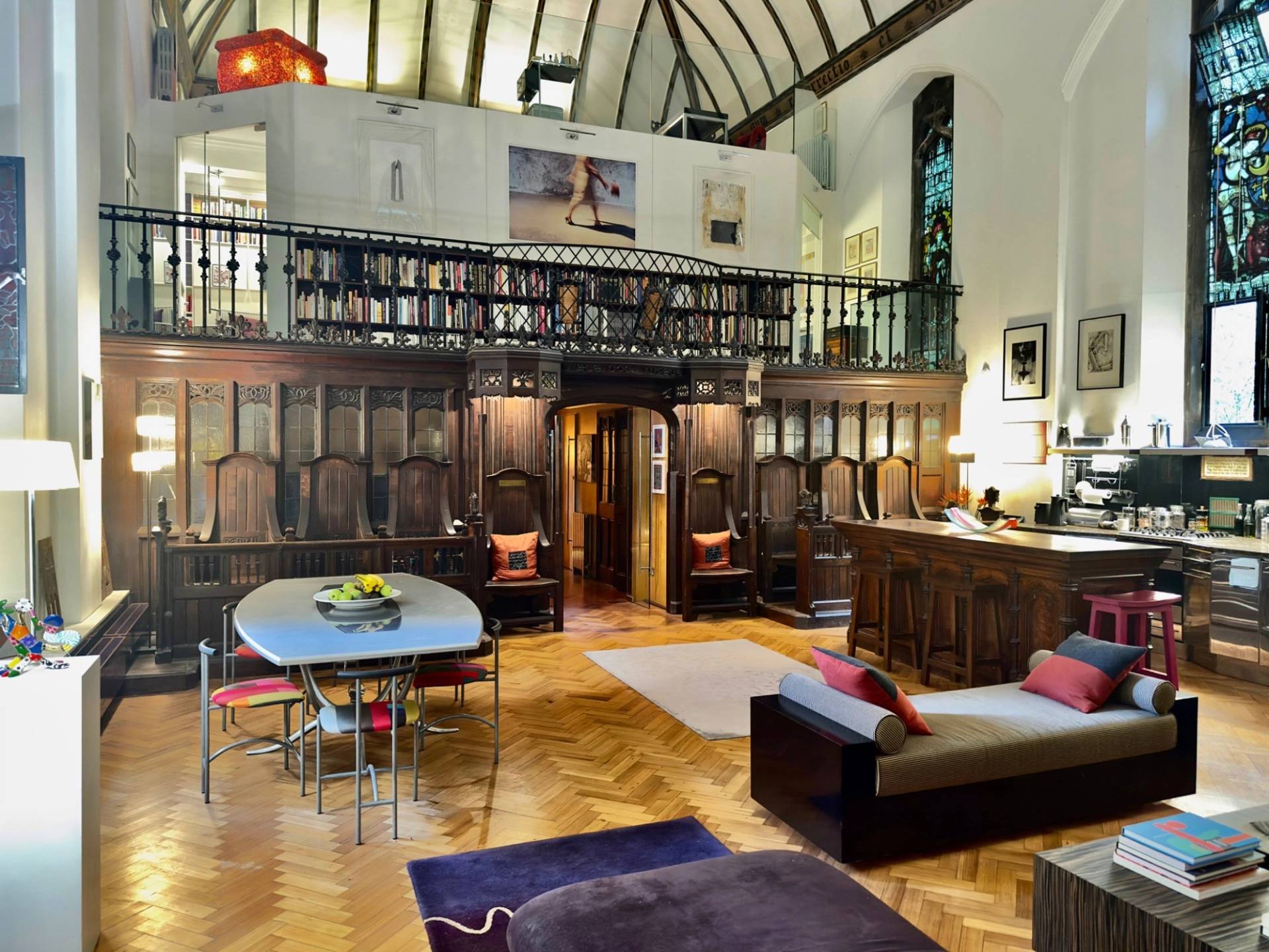 Wide view of the open-plan chapel hall for event and filming hire in Oval SE5 by Love Locations, displaying carved timber panelling and overhead library balcony.