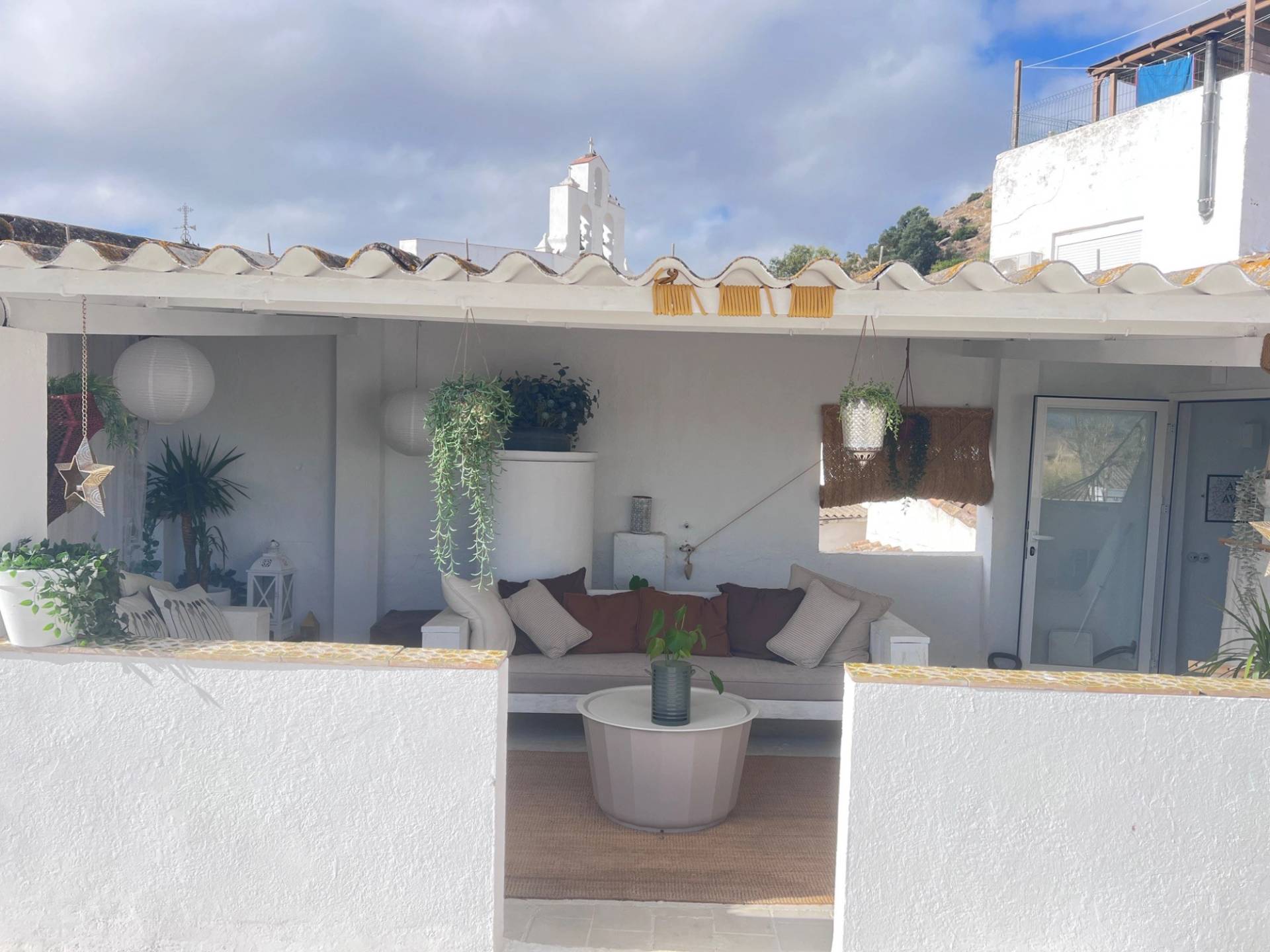 Sheltered roof terrace seating area photoshoot location in Jimena de la Frontera by Love Locations, displaying low white bench seating, neutral cushions, and bright Andalucian sunlight.