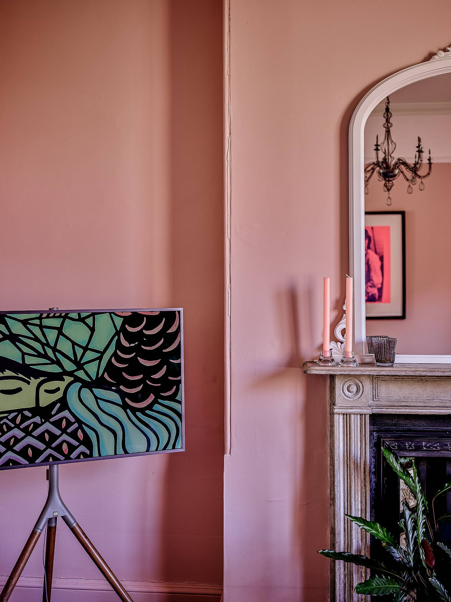 Dusty pink wall corner showcasing a period fireplace mantelpiece and contemporary floor lamp, Love Locations.