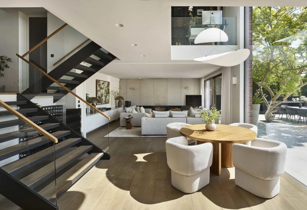 Architect-designed open-plan living space with a black floating staircase and oak floors, available via Love Locations.