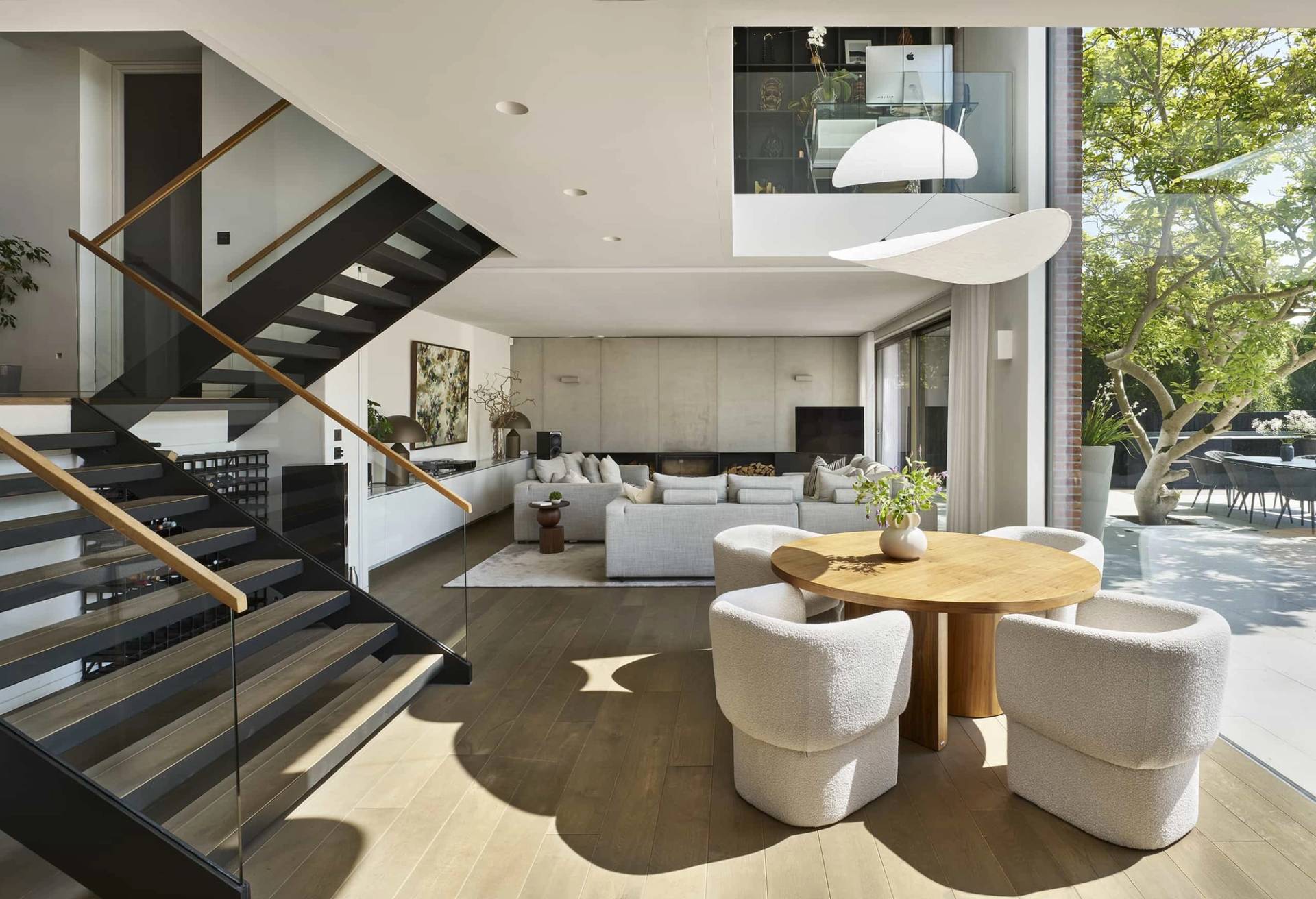 Architect-designed open-plan living space with a black floating staircase and oak floors, available via Love Locations.