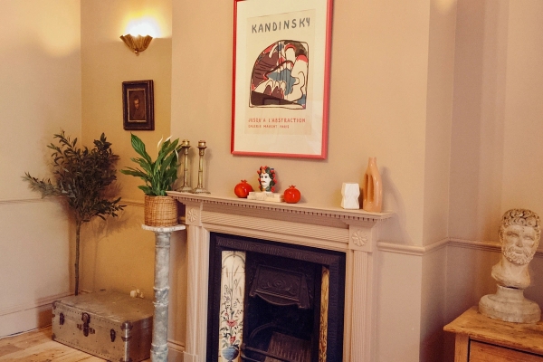 Elegant fireplace mantlepiece featuring a vintage framed art print and decorative candles, perfect for interior lifestyle lookbooks, Love Locations TW7.