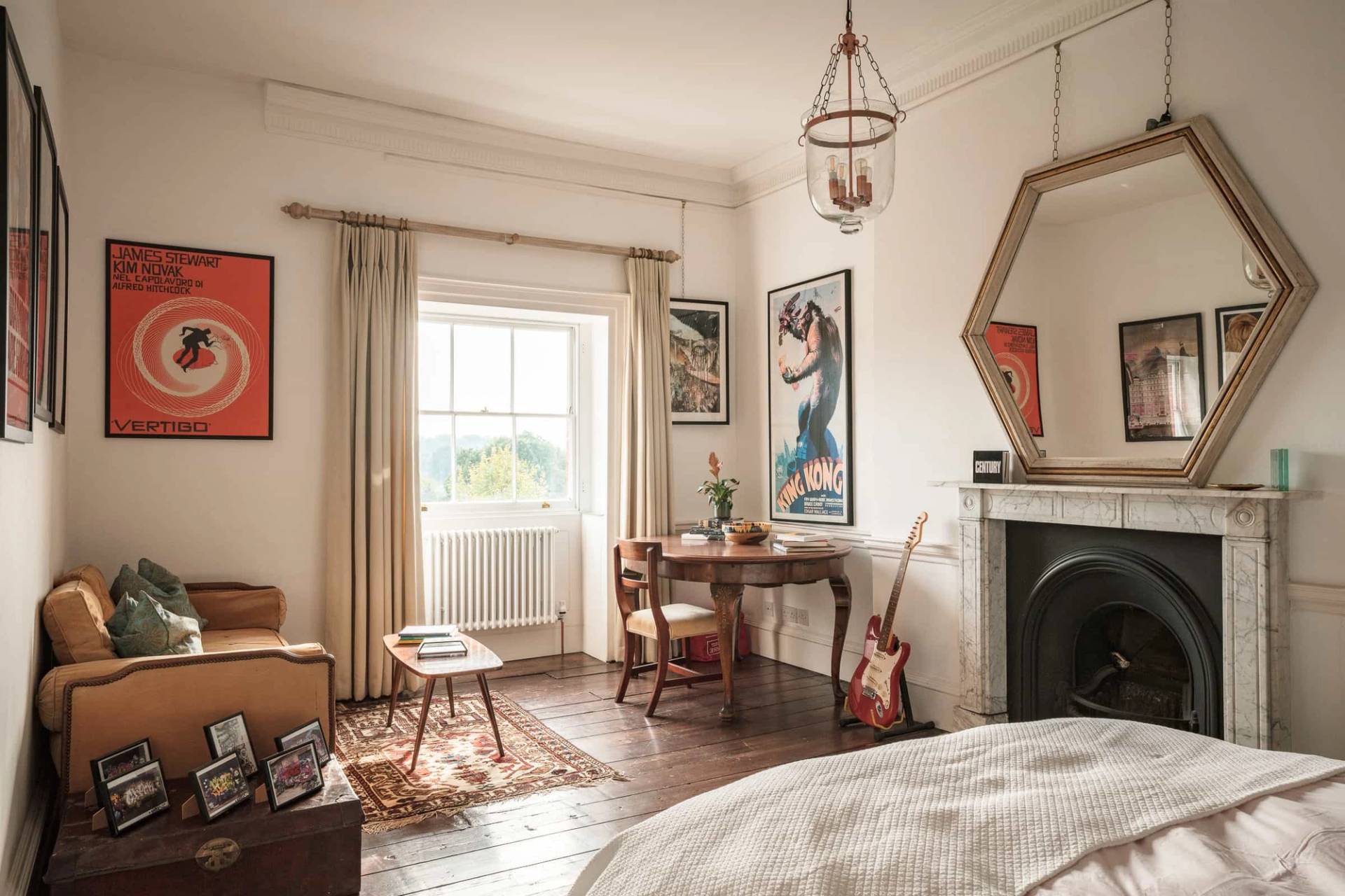 Guest bedroom with a writing desk, electric guitar, period fireplace, and sash window light, Love Locations RG42.