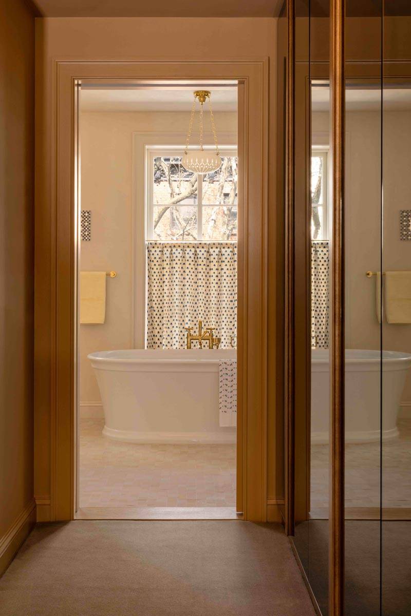  Light-filled bathroom view framed by wood-paneled doors in a 19th-century Brooklyn townhouse available via Love Locations.
