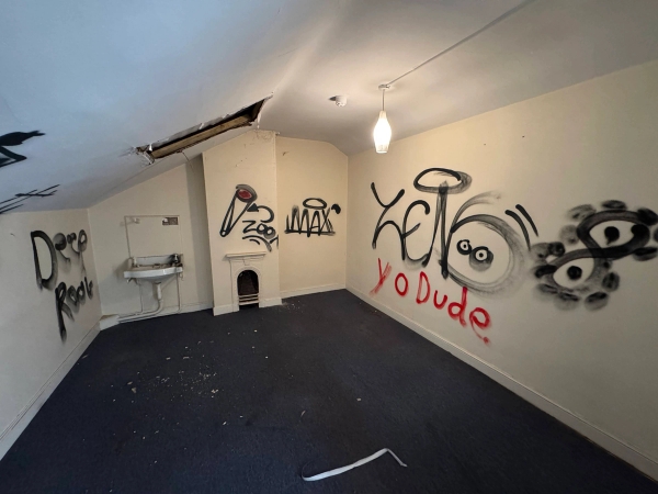 Creepy empty house film set featuring a small corner sink, period fireplace frame, and heavy wall graffiti, Love Locations NG9.