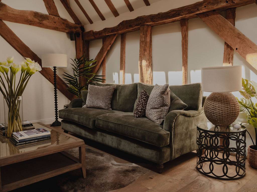 Olive green velvet sofa set on light wood floorboards in a cozy attic-style room with exposed beams, ideal for furniture brand shoots, Love Locations RG9.
