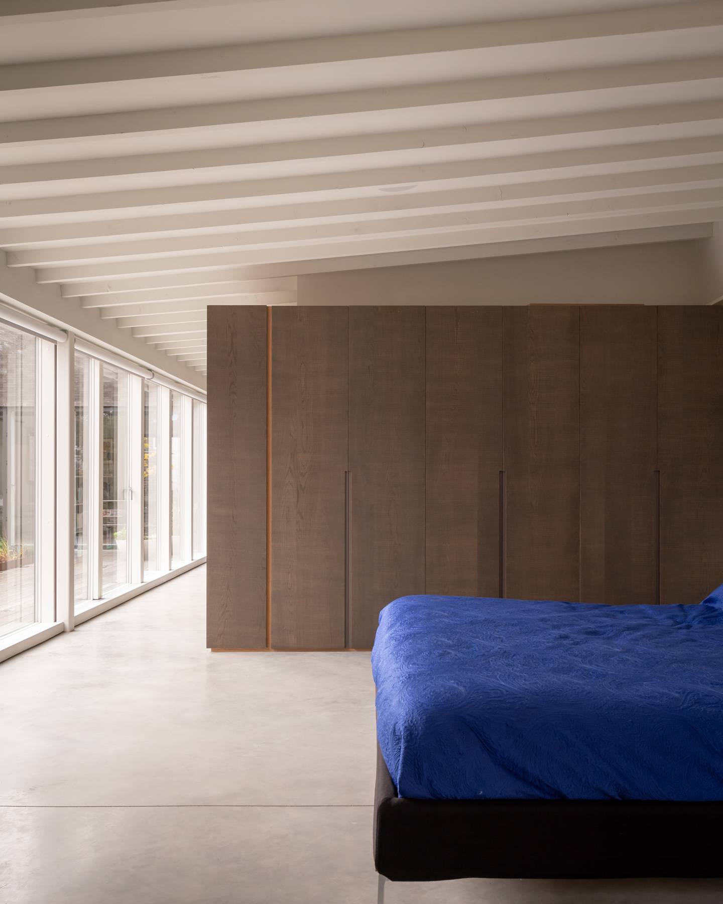 Master bedroom dressing room with full-height timber wardrobes and exposed white joist ceiling, Love Locations BN3.