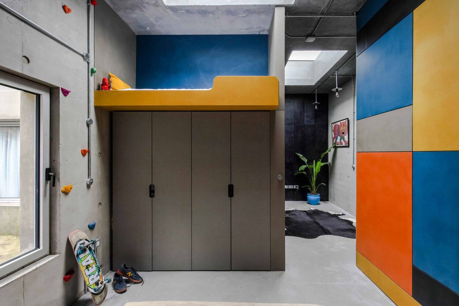 Modern industrial bedroom mezzanine with mustard yellow bunk bed frame, dark wardrobe storage, and concrete walls, Love Locations BN7.