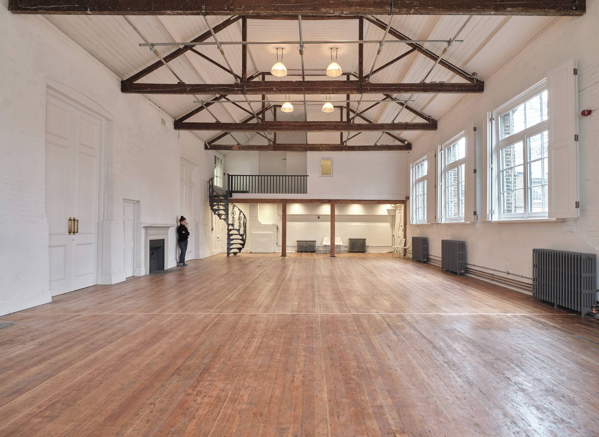 Empty double-height hall venue with wooden floors, high ceilings, and industrial roof beams in Shoreditch, East London, ideal for fashion shows and filming, Love Locations E2.