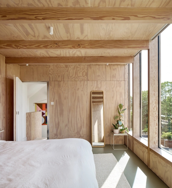 Architect-designed bedroom with birch plywood wall panelling and full-height vertical timber windows, Love Locations E17.