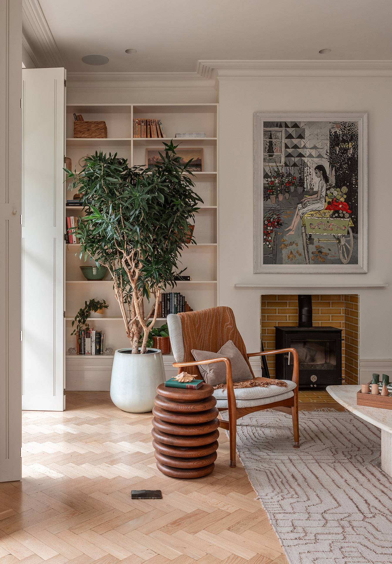 Cozy reception room alcove with an armchair, statement ceramic side table, large houseplant, and artwork, perfect for interior design catalog shoots, Love Locations TW1.
