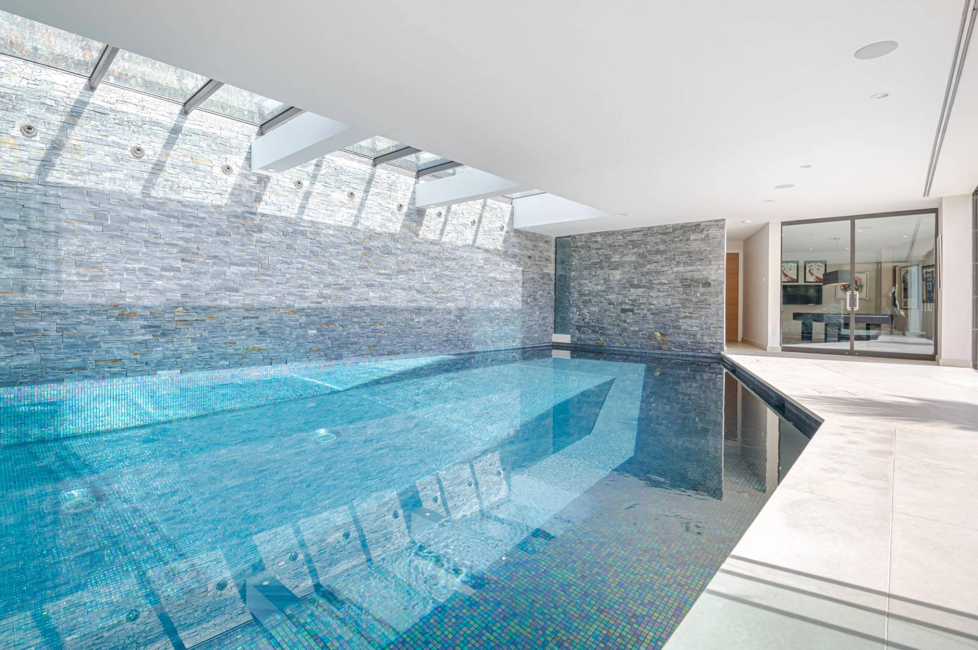 Luxury indoor swimming pool shoot location in Kingston upon Thames, KT2 featuring slate stone wall tiles and overhead skylights via Love Locations.
