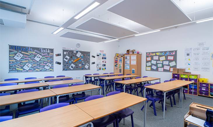 Secondary school classroom photo location with modern acoustic ceiling panels, pinboards, and organized study tables through Love Locations.