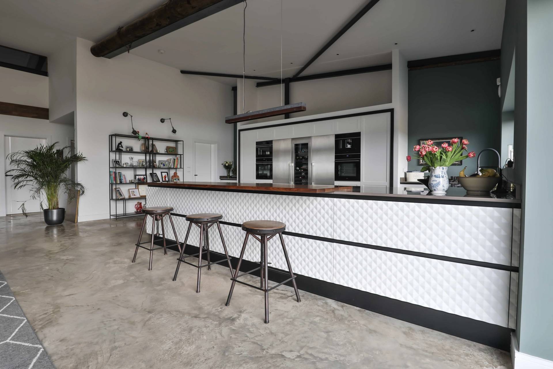 Breakfast bar counter with textured white tiles and wooden bar stools in a luxury converted barn location, Love Locations CV23.