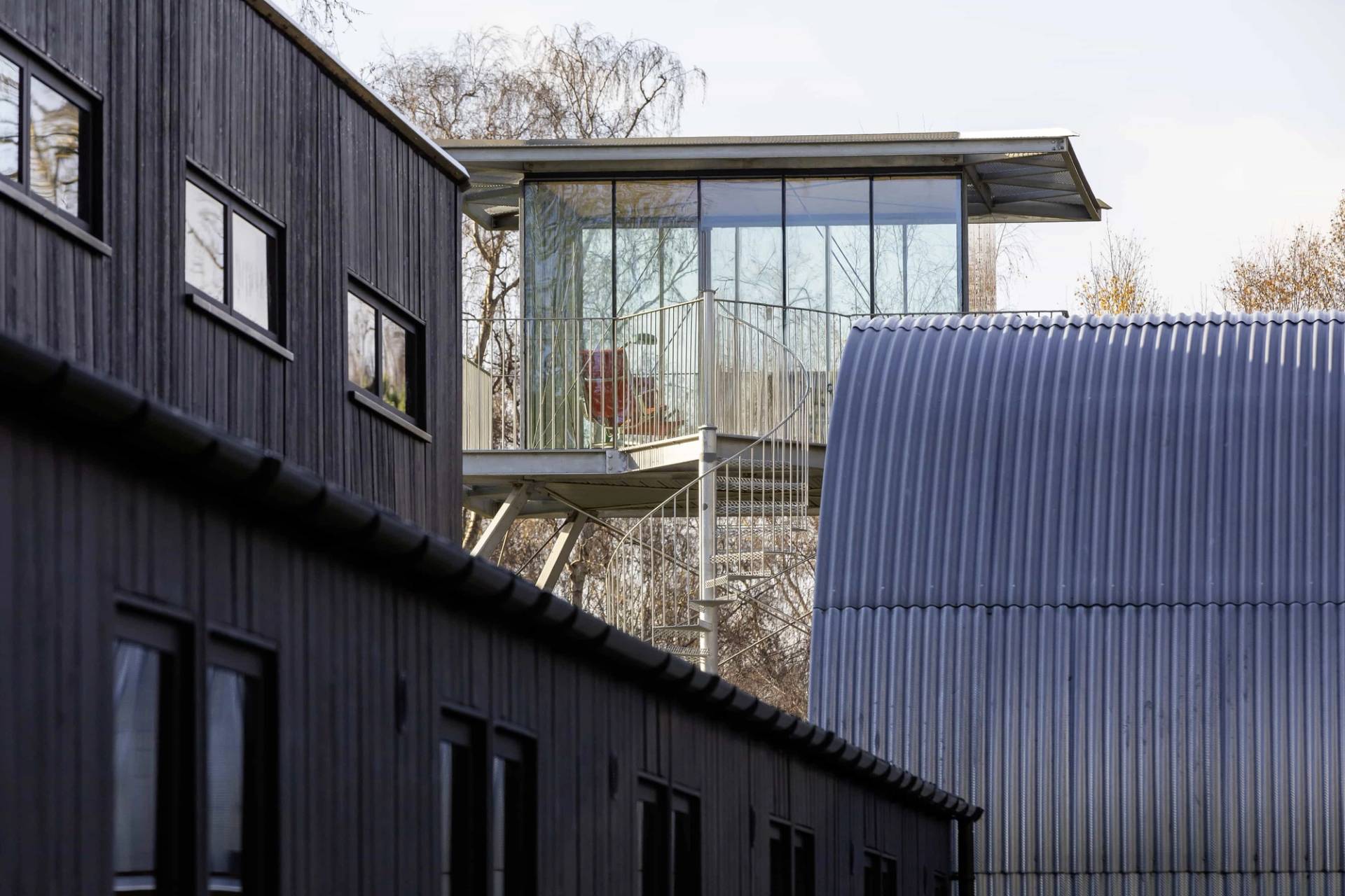 Modern dark timber building facade connected to an elevated glass observation tower, Love Locations IP17.