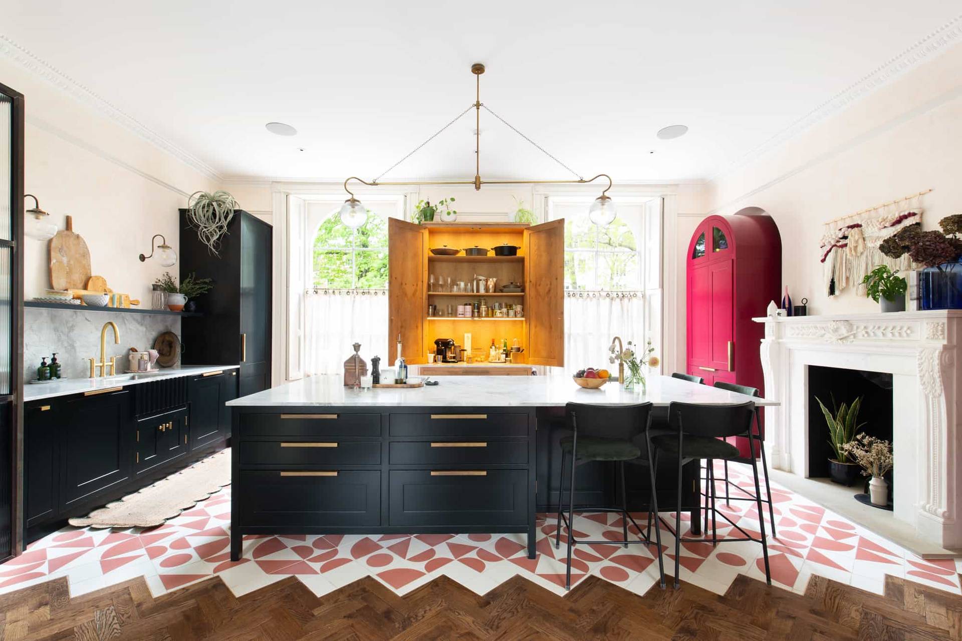 Contemporary luxury kitchen in Camberwell, SE5 featuring open timber drinks cabinet, marble island, and pink geometric tile floor via Love Locations.