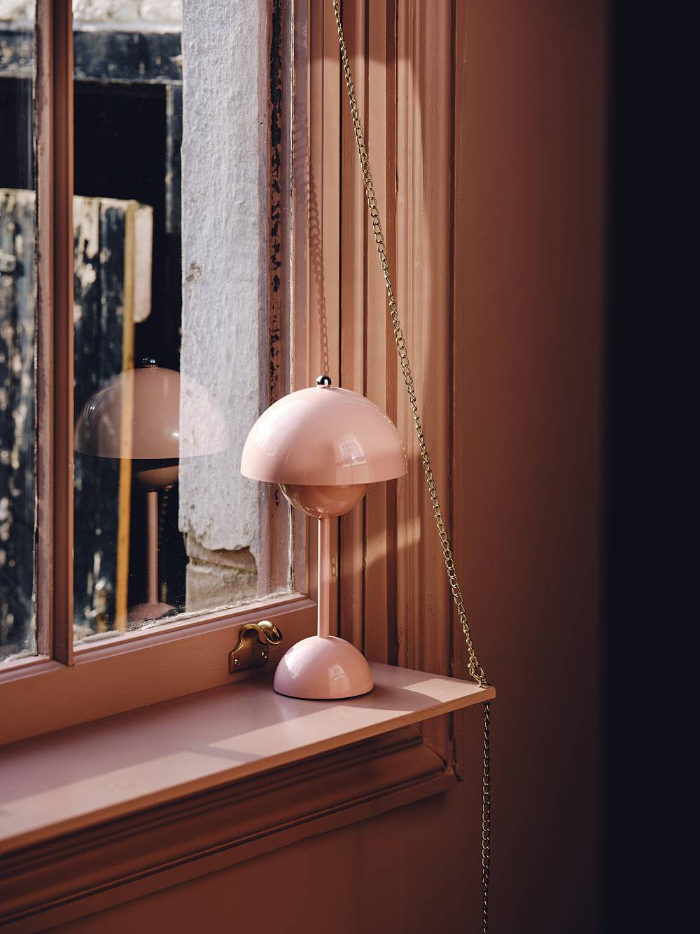 Pink table lamp set on a wooden vanity table cast in natural sunlight, Love Locations CR0.