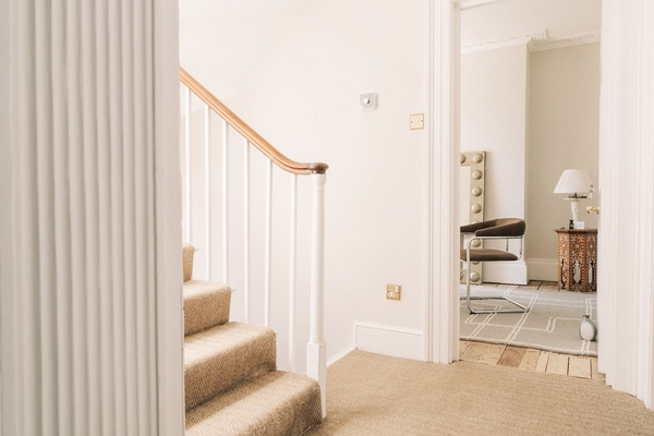 Traditional white staircase banister and wooden handrail detail on a multi-level residential property in SW9, Love Locations.