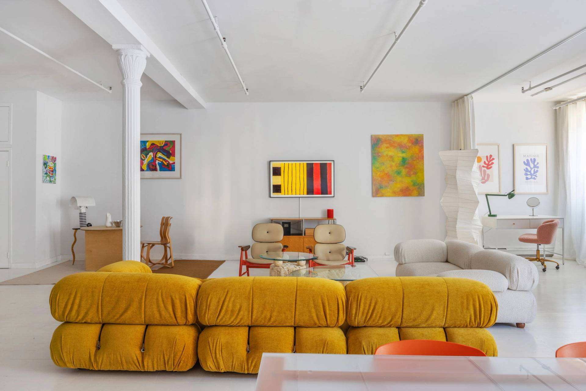 Contemporary living room production layout in an all-white Tribeca NY 10007 loft from Love Locations, featuring a mustard yellow modular sofa and track lighting.