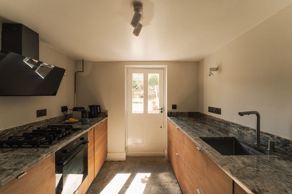Bright kitchen workspace leading out through a glass-panelled back door to the garden, perfect for natural light lifestyle shoots, Love Locations.