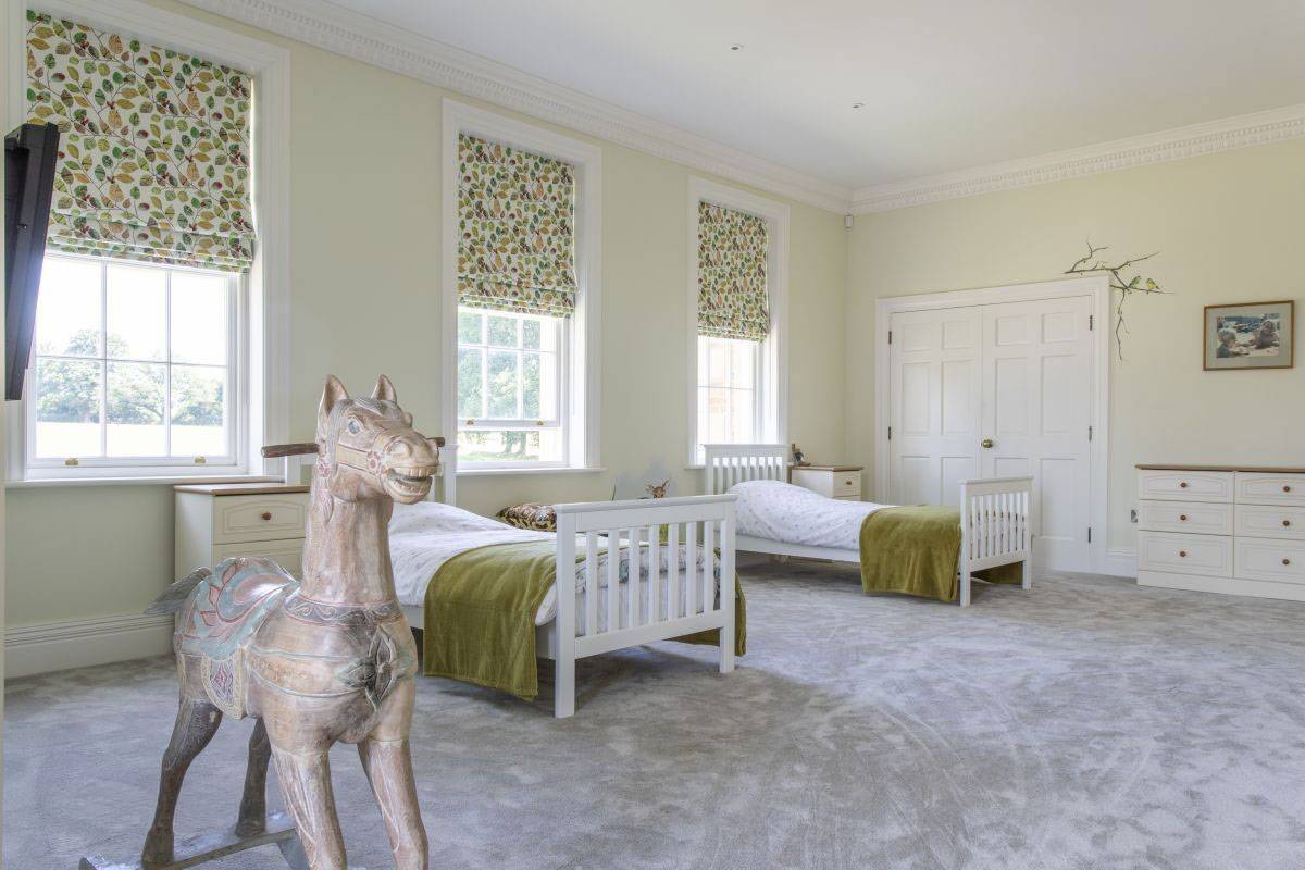 Charming, bright children's bedroom with twin beds and a vintage rocking horse, ideal for family brand shoots via Love Locations, Haywards Heath.