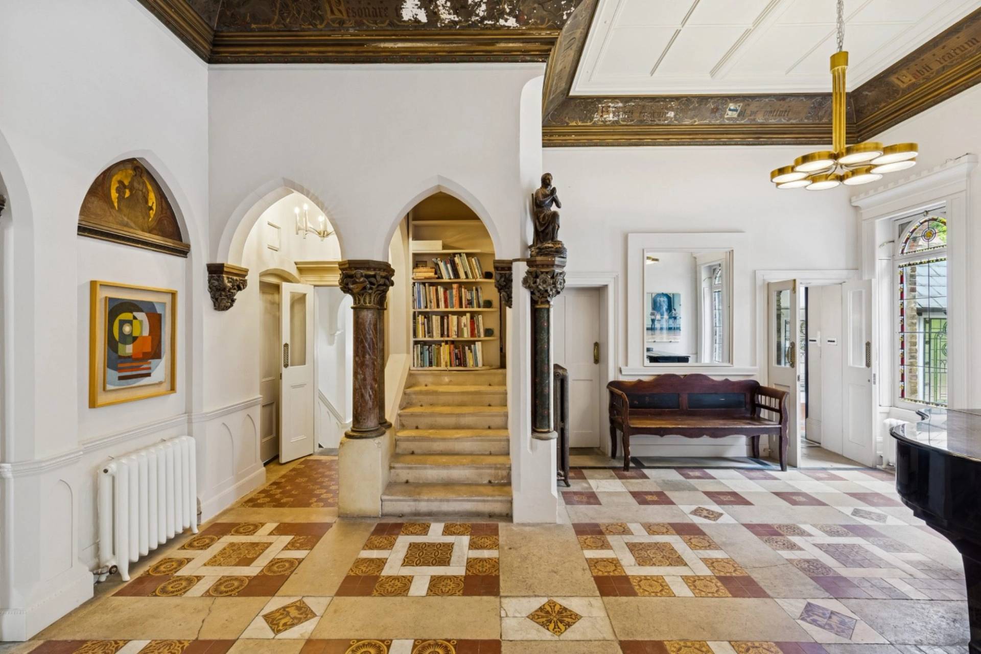 Grand foyer and stone pillar archways in a gothic style house in Hampstead NW3 available via Love Locations.