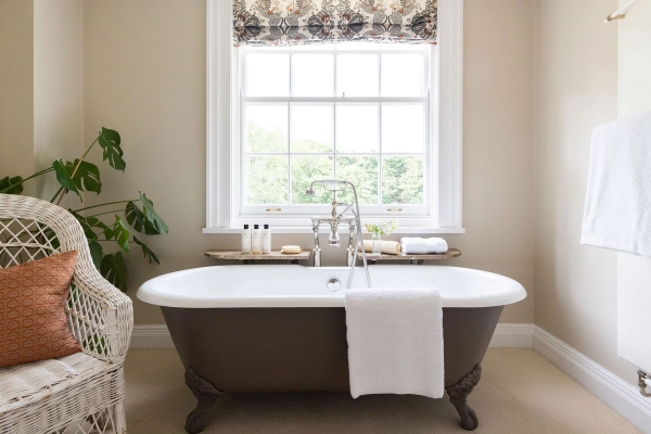 Love Locations luxury bathroom shoot location Steyning Ashington BN44: Heritage bathroom featuring a deep freestanding roll-top bath with chrome mixer taps under a bright window, perfect for beauty ads.