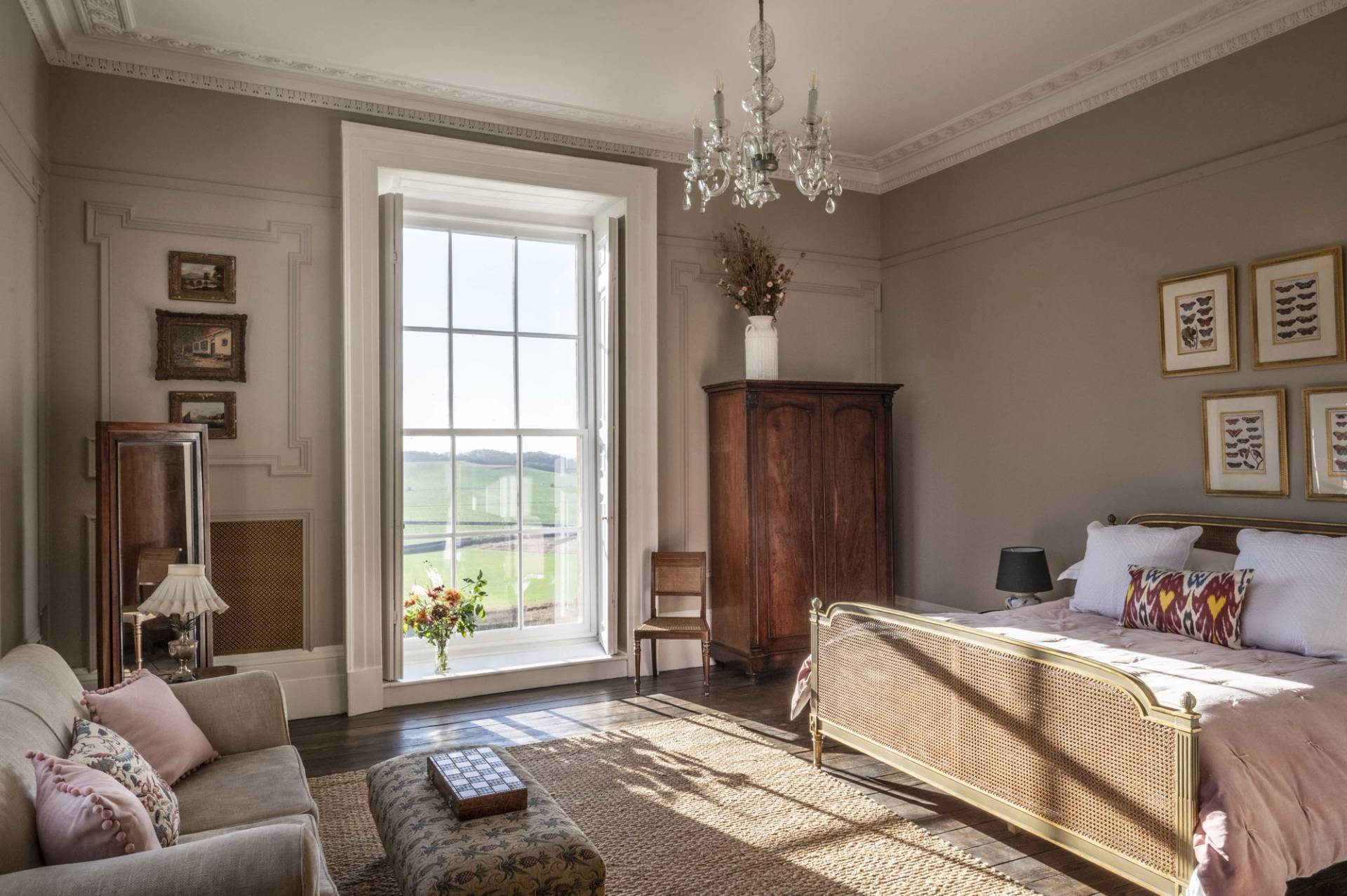 Light-filled bedroom layout highlighting traditional wall mouldings and sash windows overlooking green fields, ideal for home decor lookbooks, Love Locations LE7.