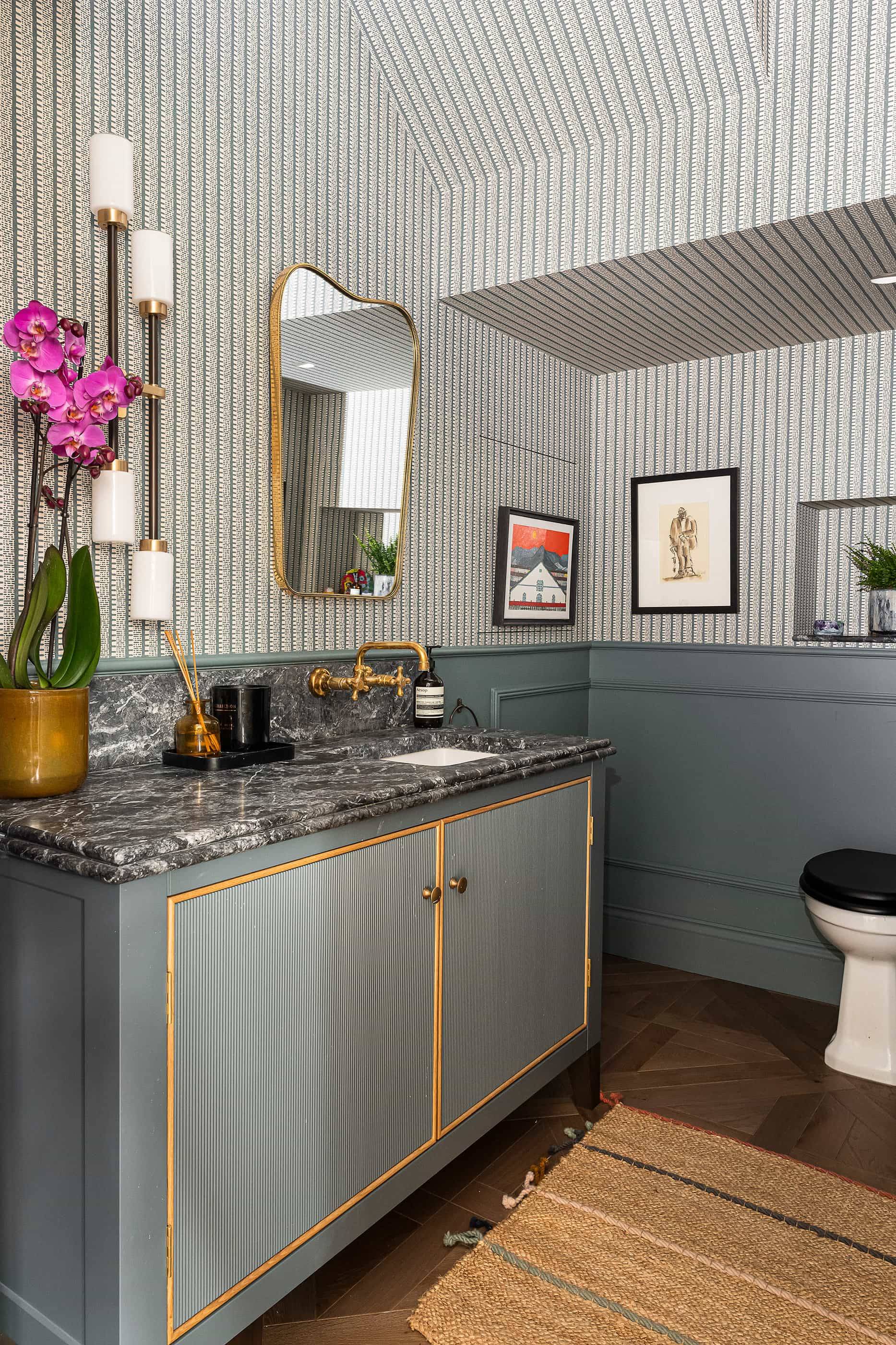 Luxury powder room hero cover image in Queens Park, NW6 featuring striped ceiling wallpaper, dark grey panelled walls, brass-trimmed vanity with marble top, and gold mirror, the ultimate high-visibility backdrop for luxury beauty campaigns, fashion editorials, and commercial productions via Love Locations.