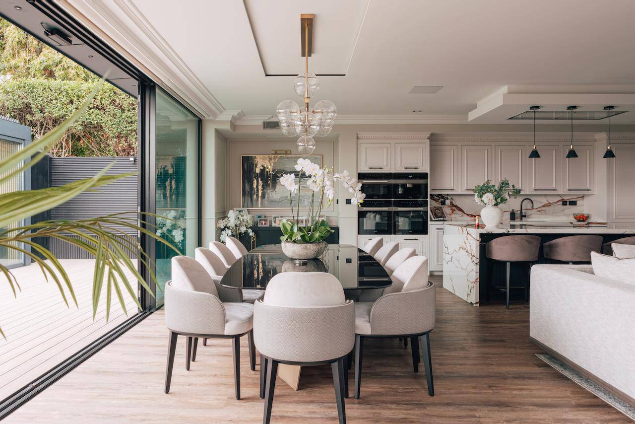 Formal dining room setup with an oval marble dining table, cream velvet chairs, and full-length sliding glass patio doors, ideal for tableware lookbooks, Love Locations W5.
