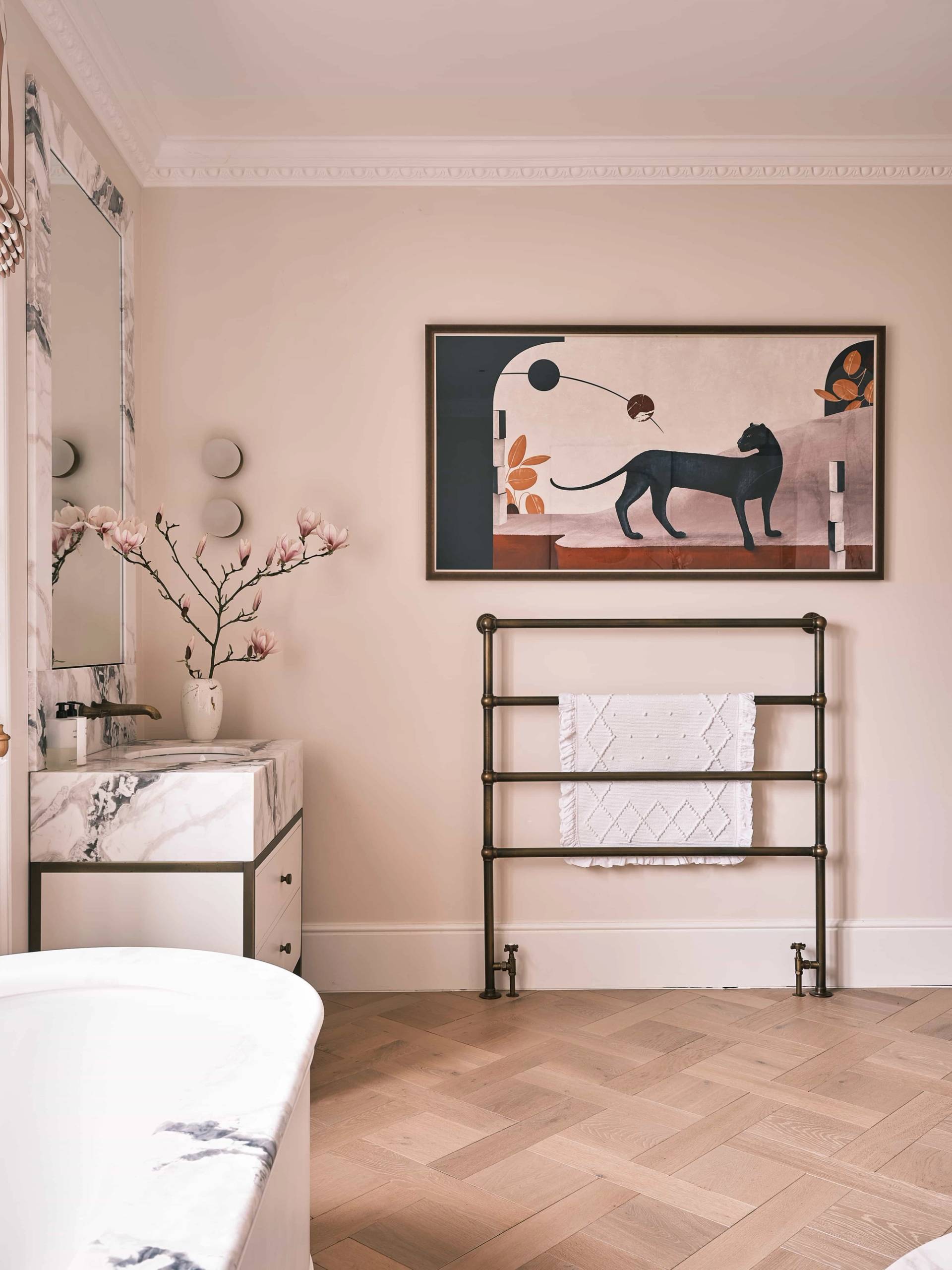 Spacious master bathroom featuring marble vanity basins, dark metal towel radiator, and blush pink walls, Love Locations.