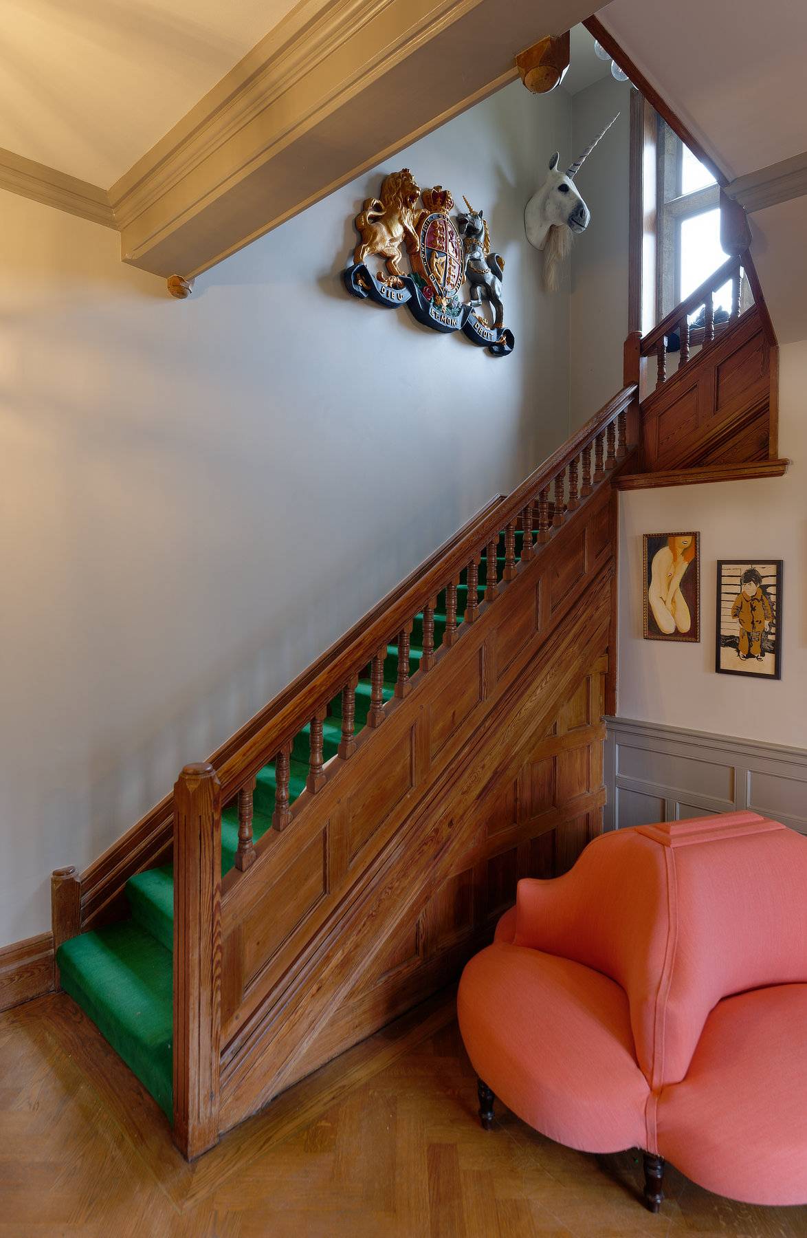 Carved dark wood staircase balustrade set against light walls in a Cotswold manor home, Love Locations OX7.