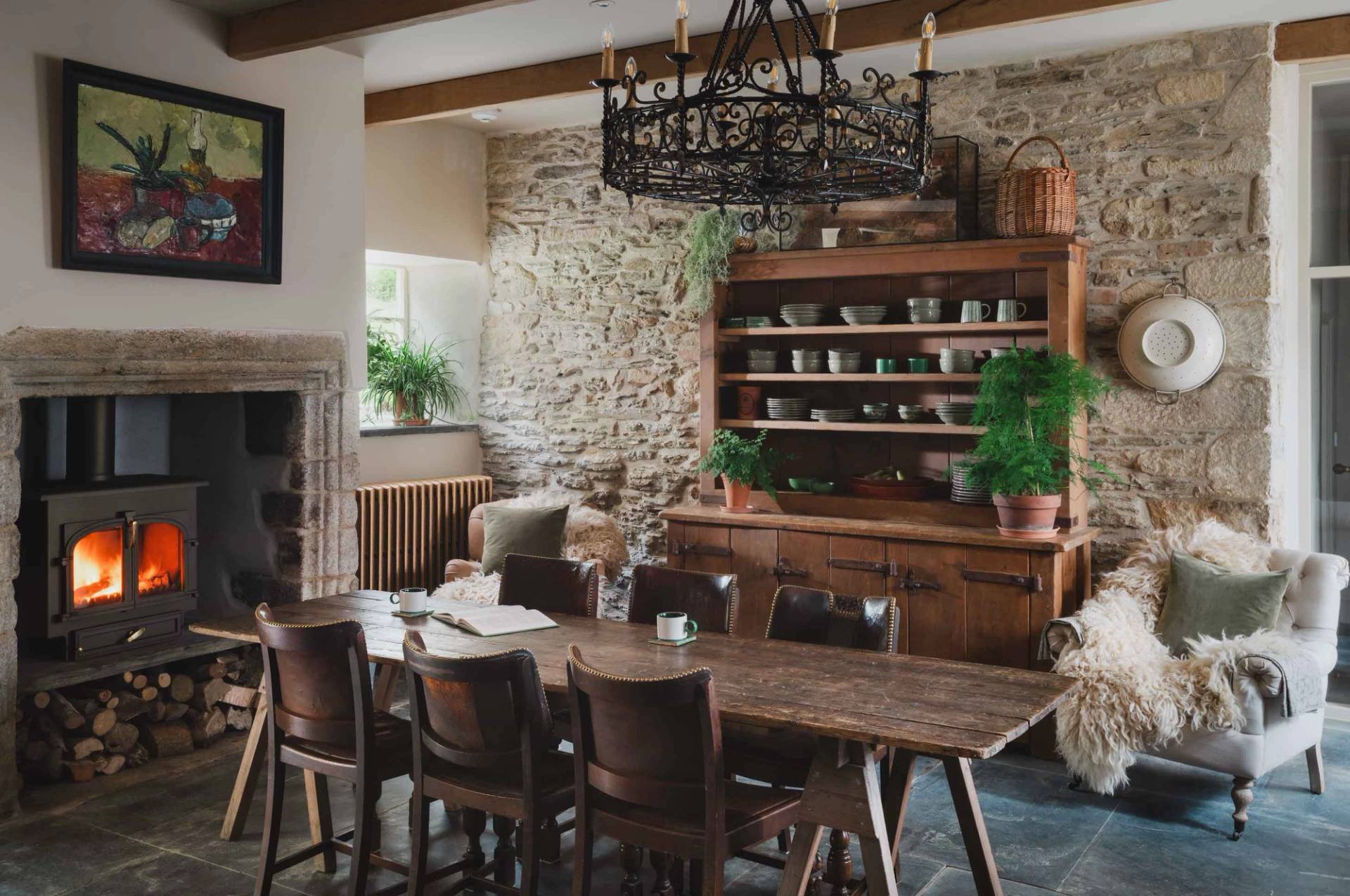 Spacious dining area in a Grade II-listed Cornish manor shoot location in Newquay TR8 by Love Locations, highlighting an extended timber dining table, stone walls, and natural slate flooring.