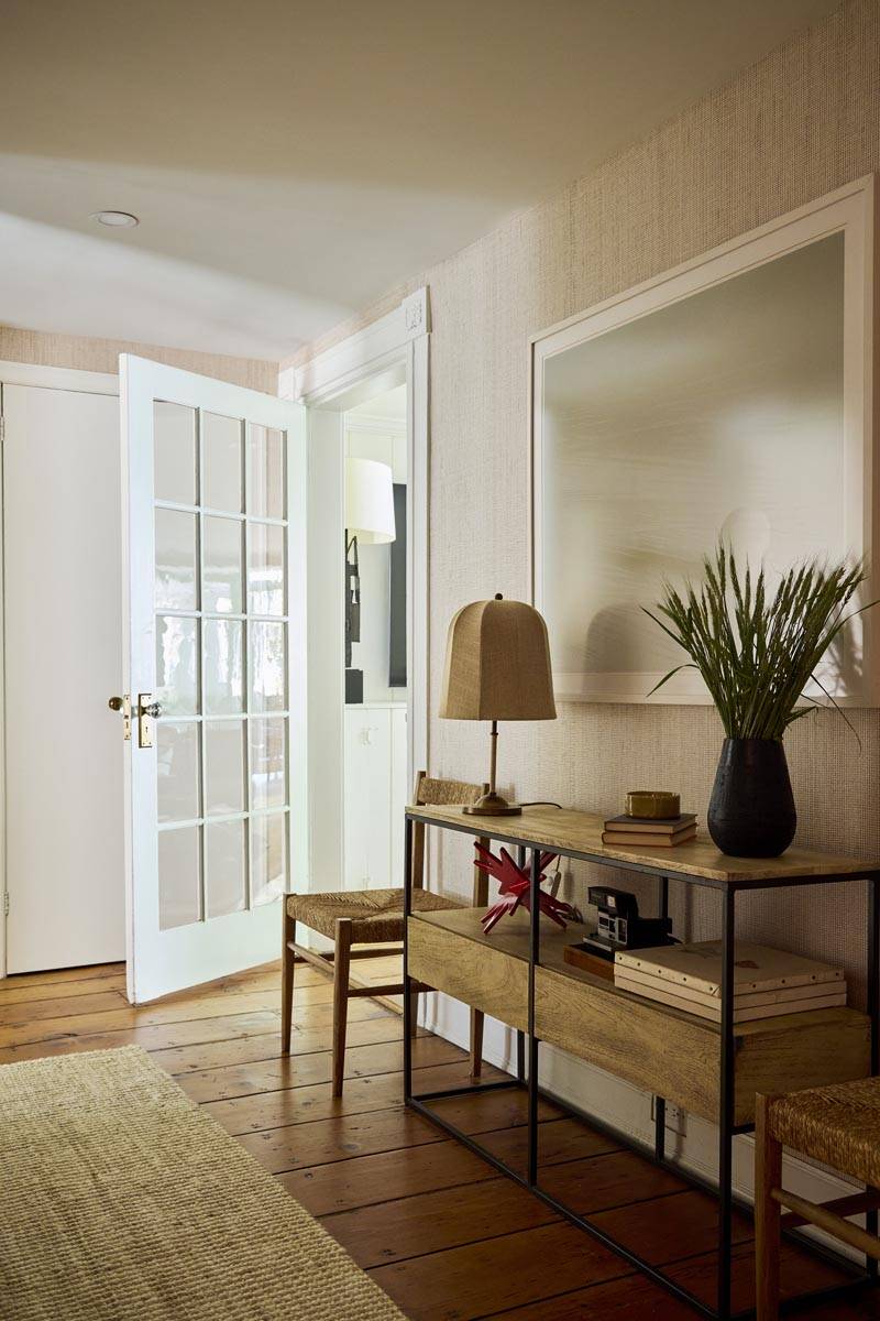 Elegant entry hall and foyer location space featuring a narrow console table, large mirror, and glass-paneled double doors in Manhattan via Love Locations.