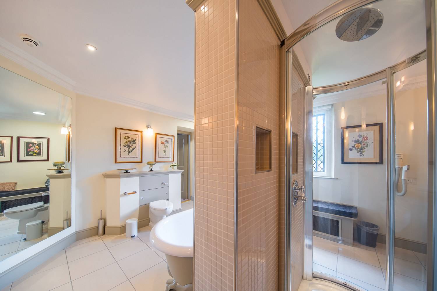 Modern ensuite shower room shoot space with beige mosaic tile pillars and glass shower enclosure by Love Locations.